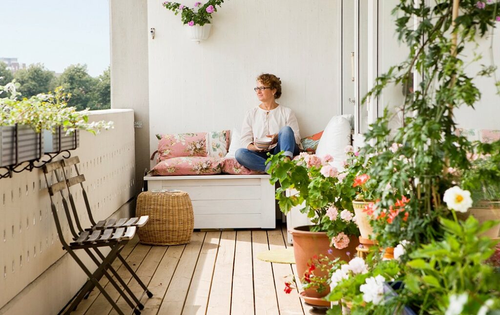 Woman admiring her containers on a balcony
